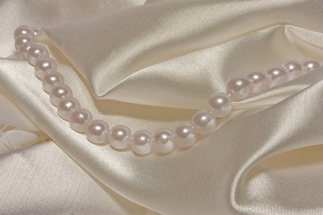 Šňůra perel položená na hedvábné látce.jpg